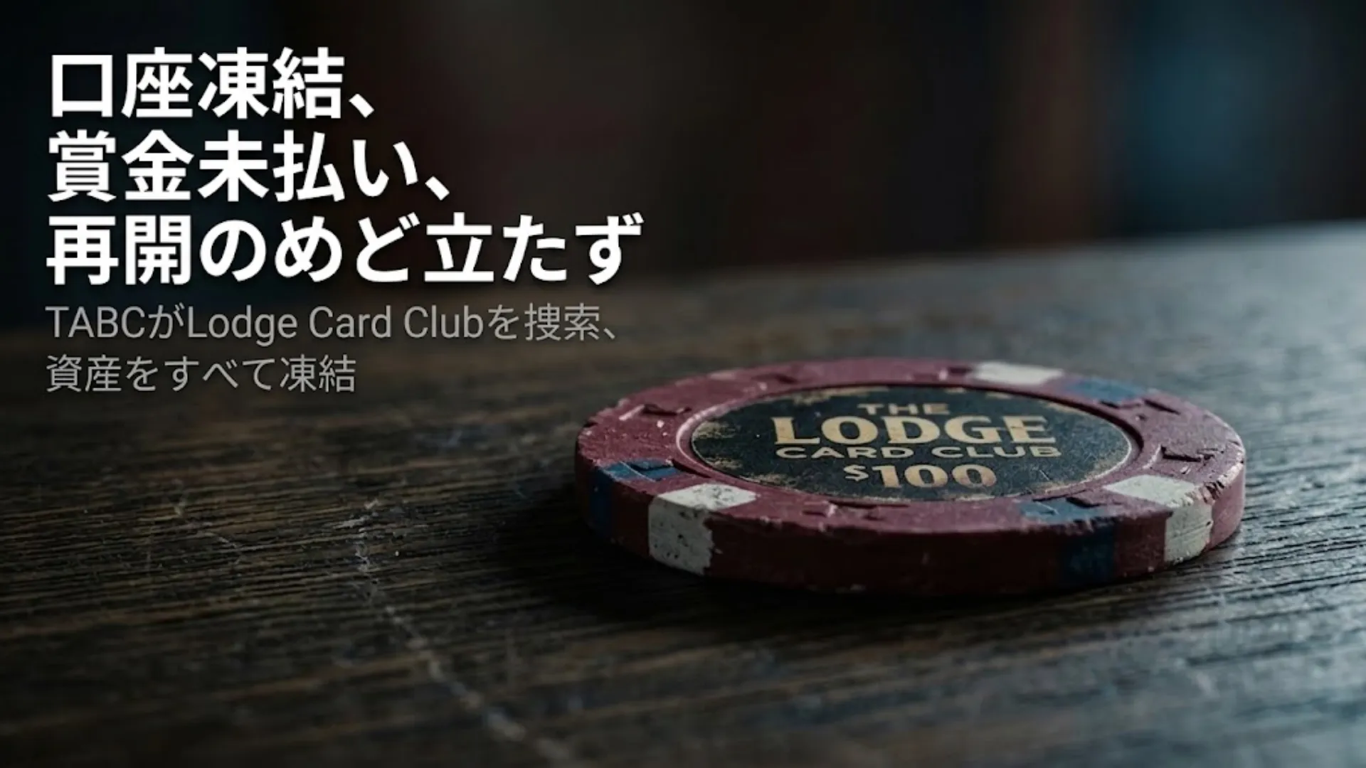 傷んだLodge Card Clubの$100ポーカーチップが暗い木製テーブルの上に置かれ、太字の白いテキストで「口座凍結、賞金未払い、再開のめど立たず」と重ねられている